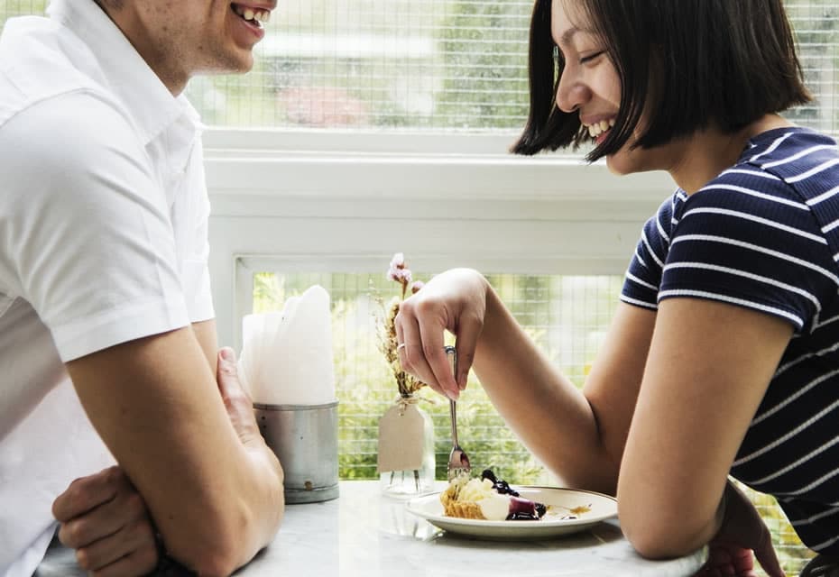 Homme et femme souriants qui mangent tranquillement