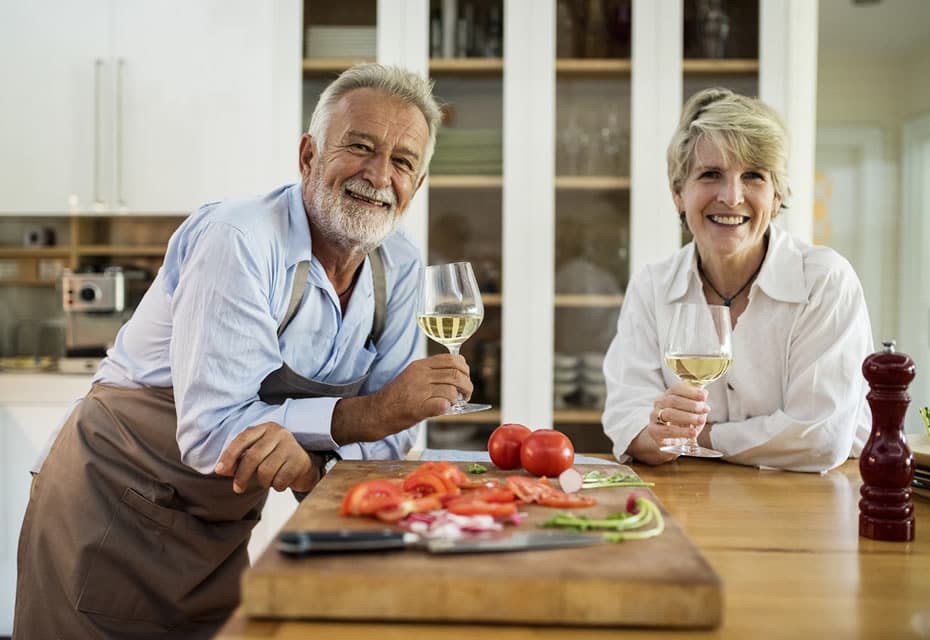 Couple heureux qui boit du vin et prépare un repas